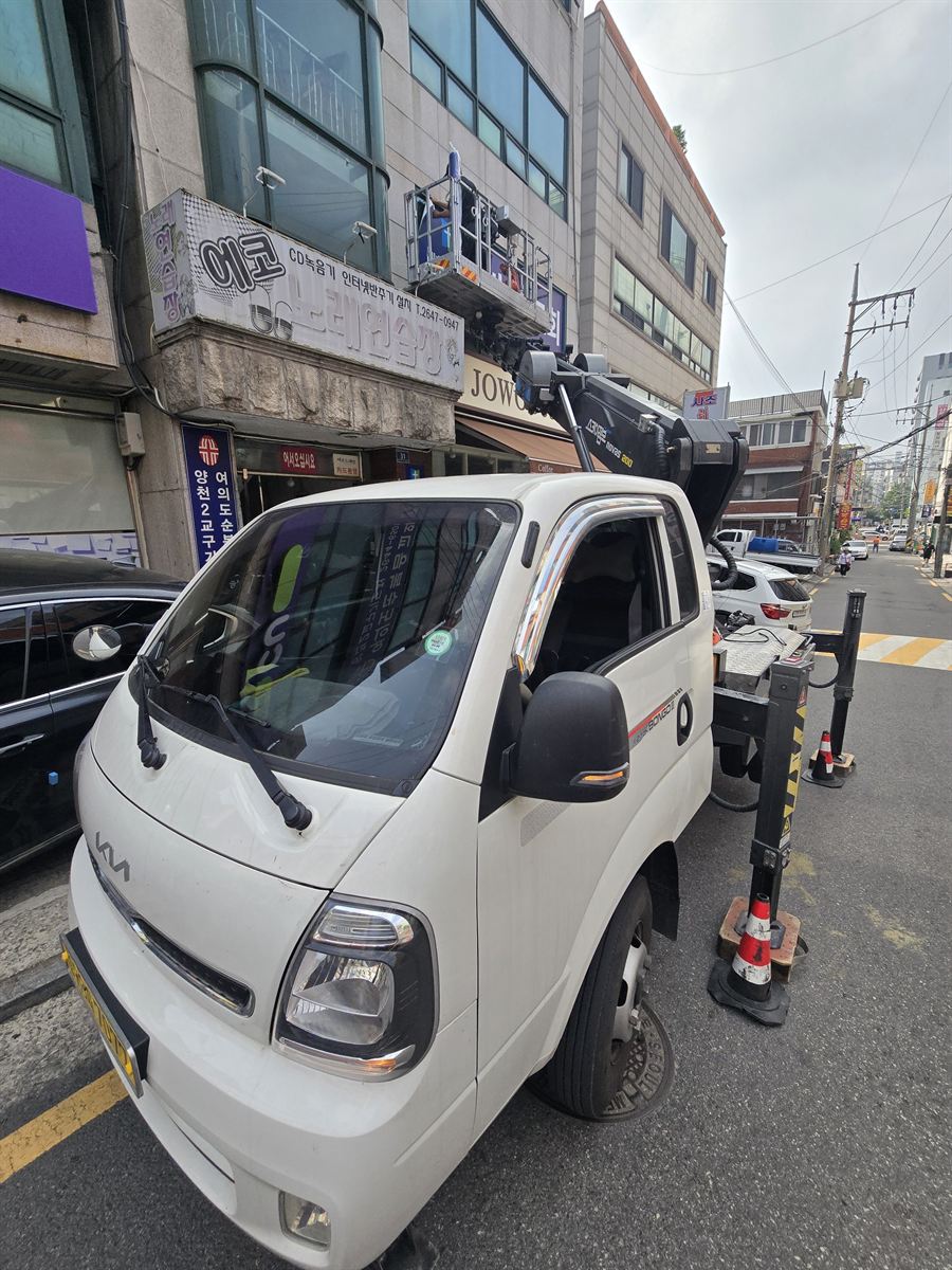 스카이차 작업대에서 건물 외벽 간판을 작업하는 모습